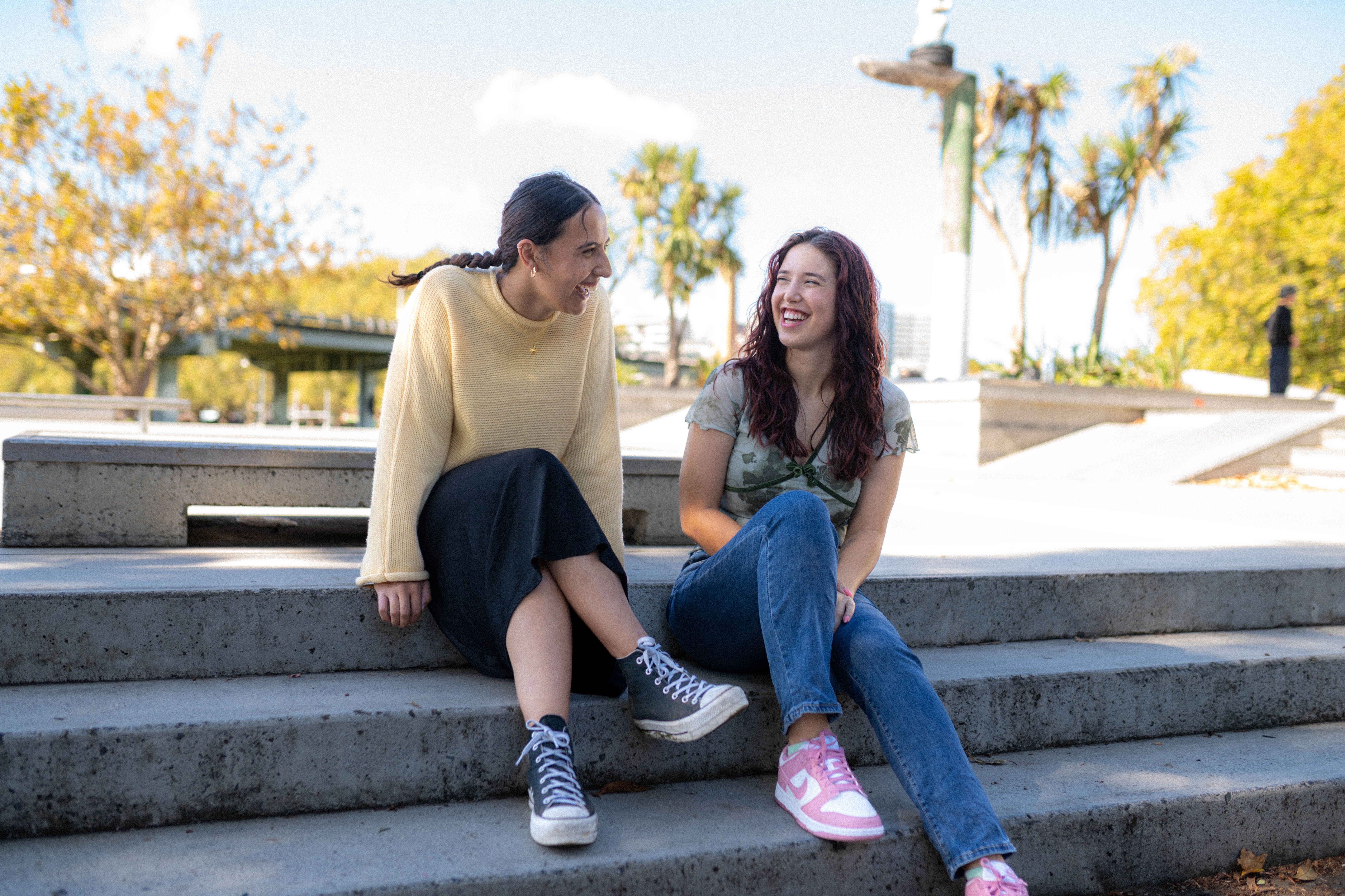 two young people impacted by cancer are walking together and laughing at a canteen programme