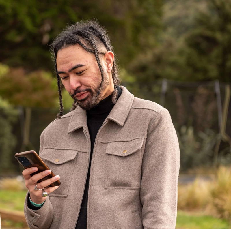 a man in a jacket is looking at his phone a man in a jacket is looking at his phone