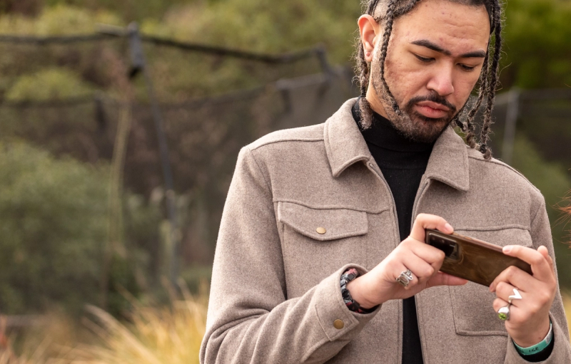 a man with dreadlocks is looking at his phone