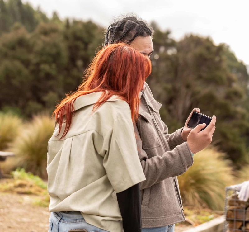 a man and a woman looking at a cell phone