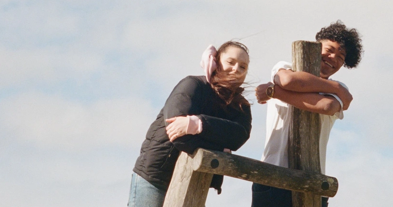 a man and a woman leaning on a wooden post a man and a woman leaning on a wooden post