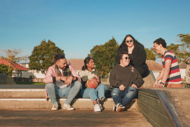 a group of people sitting on a ledge with a basketball