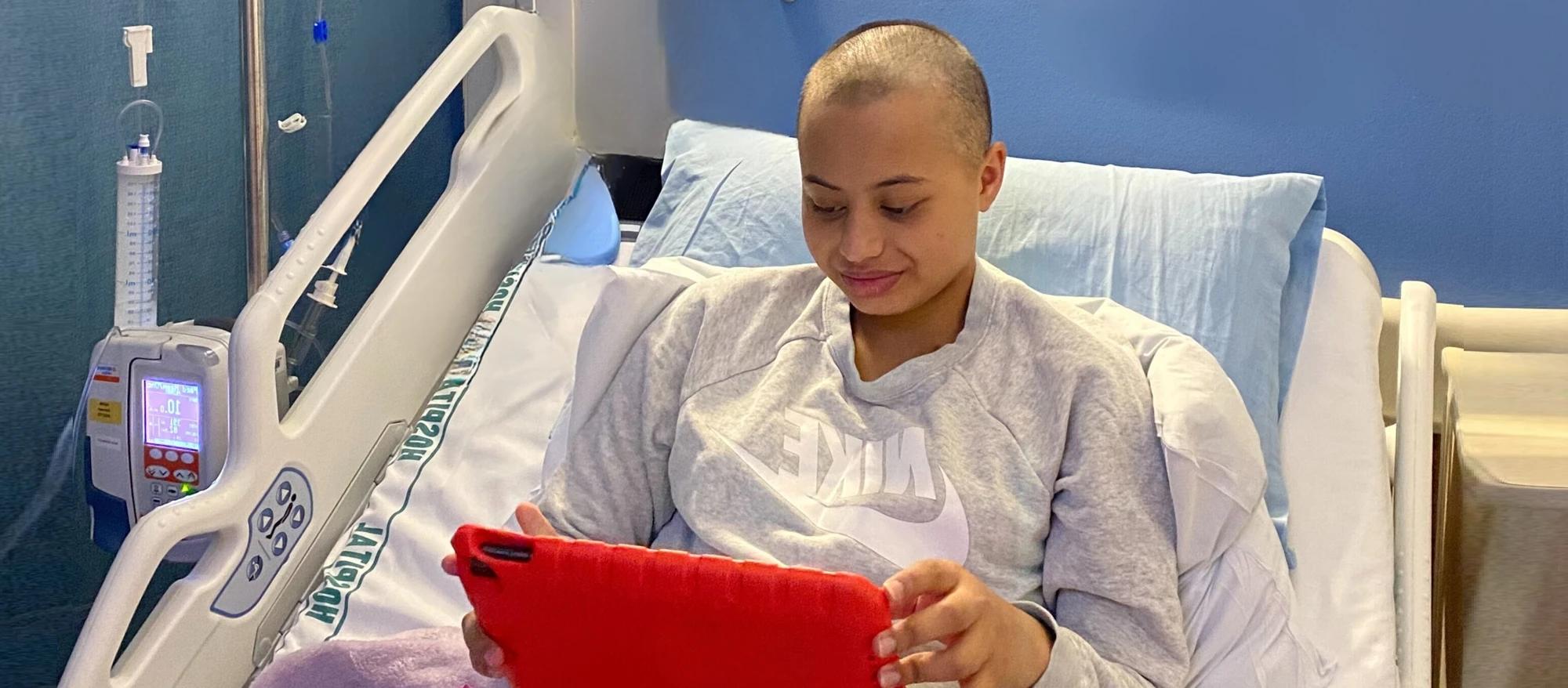 young person impacted by cancer using an ipad to stay connected