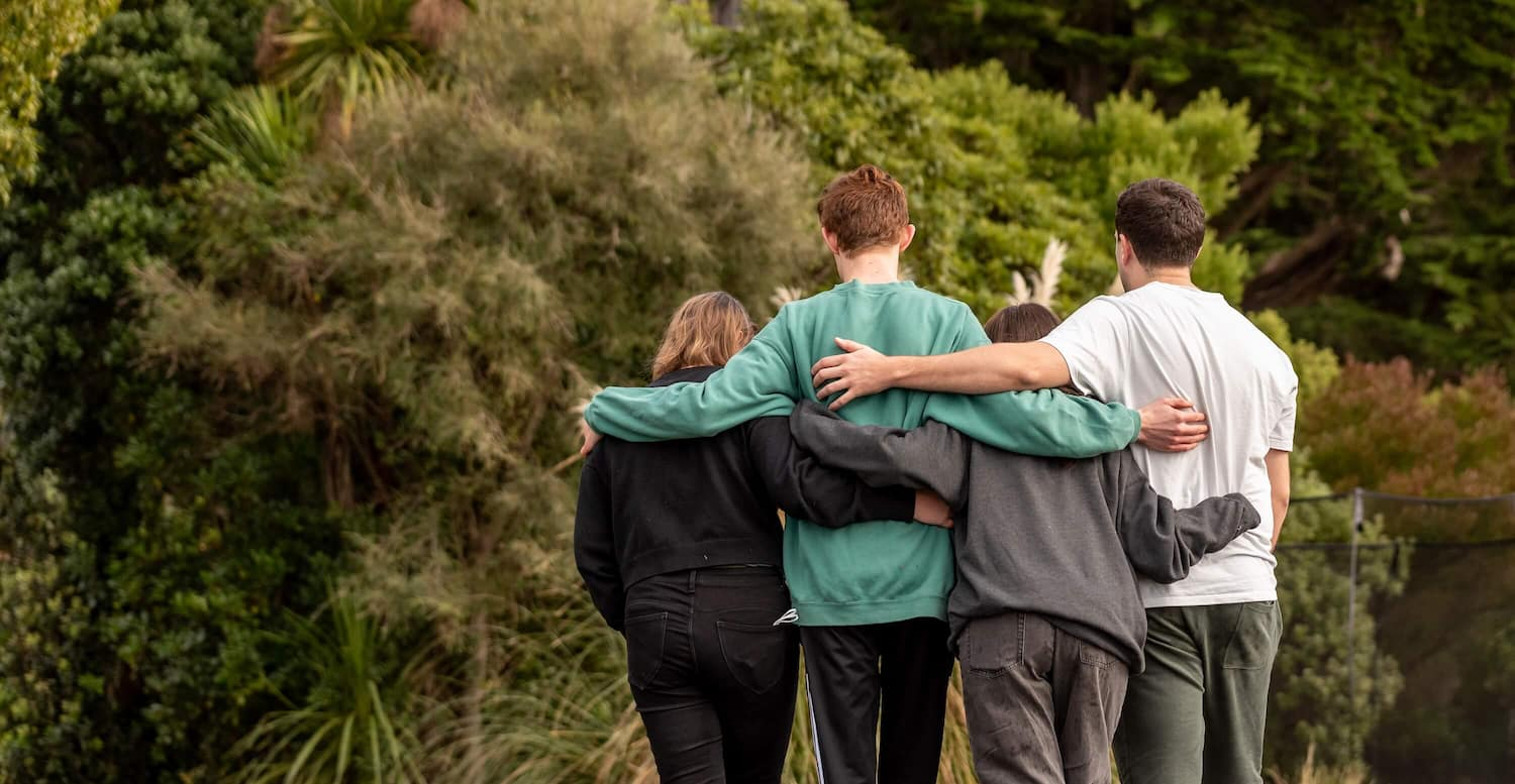 a group of people hugging each other in a park