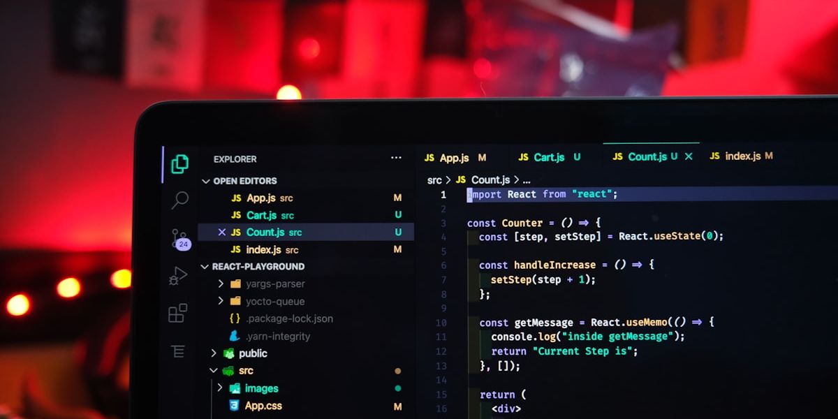 A code editor open on a screen, in a room lit in red.