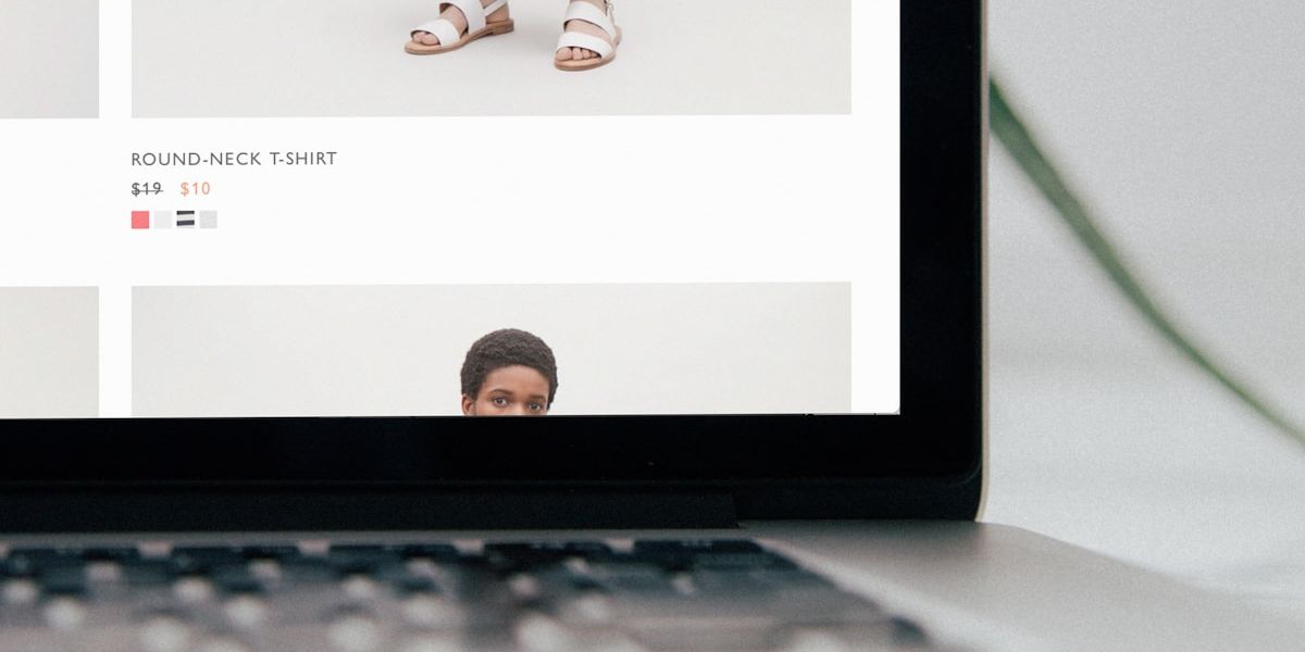 Un ordinateur portable ouvert sur la fiche produit d’une boutique en ligne de vêtements.