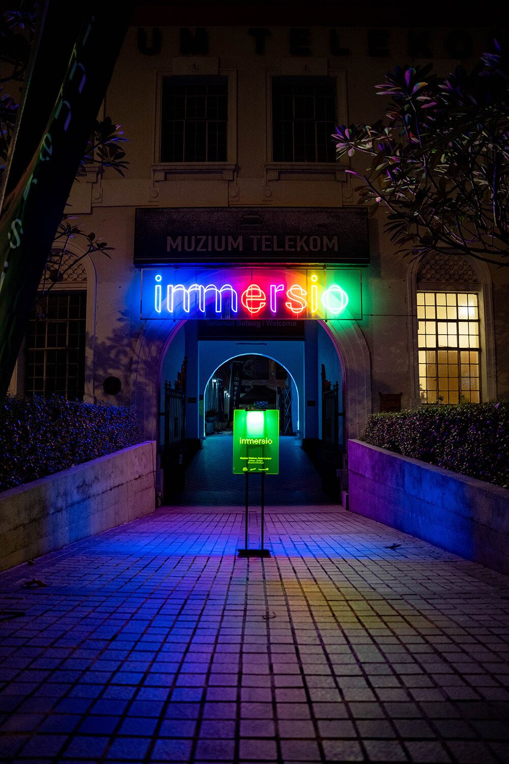 Night entrance to Muzium Telekom illuminated with the IMMERSIO sign