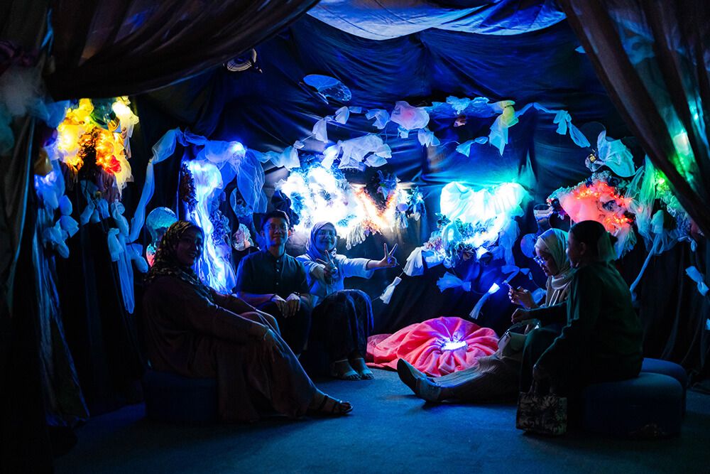 Visitors gathered around a luminous installation at IMMERSIO