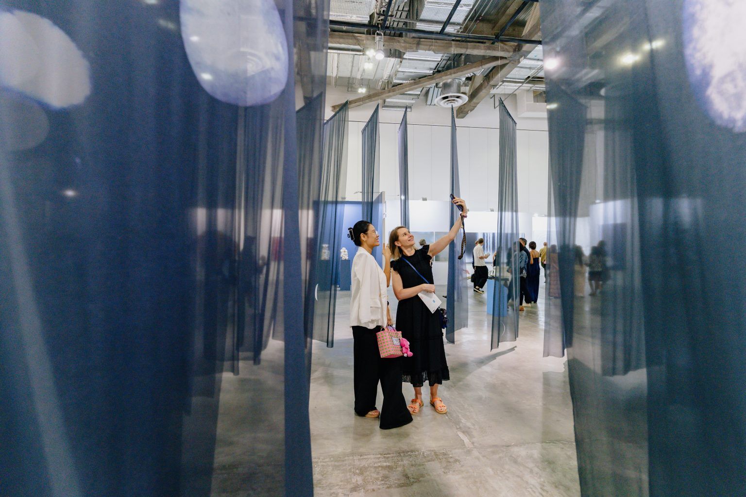Visitor viewing textile artworks at ART SG 2025