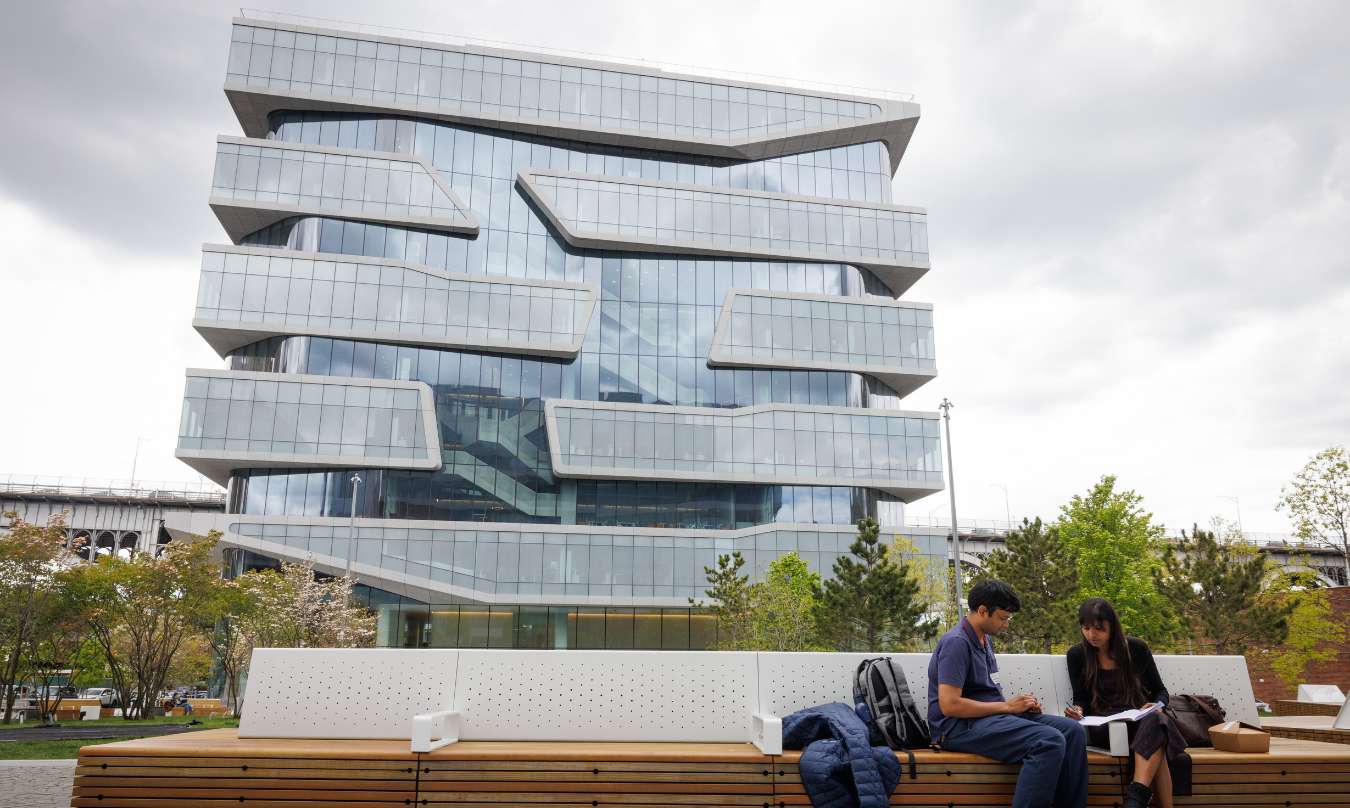 Two students sitting in front of Columbia University Business School
