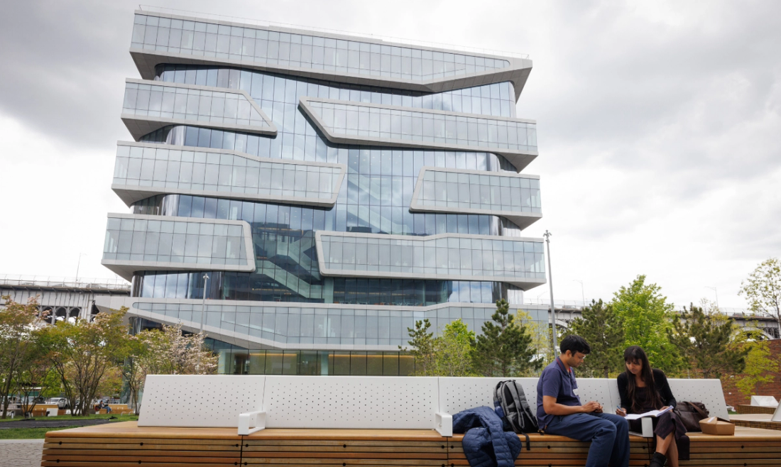 Two students sitting in front of Columbia University Business School