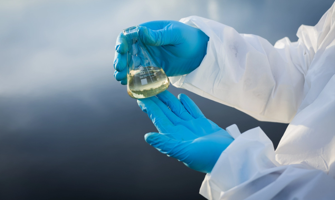 Researcher holding beaker filled with liquid