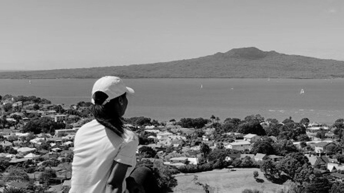 Student looking over seaside city in New Zealand.