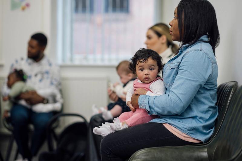 A mother holds her baby at a health clinic.