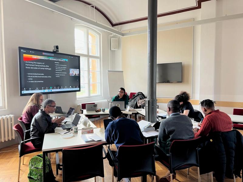 A classroom with scholars around a table.
