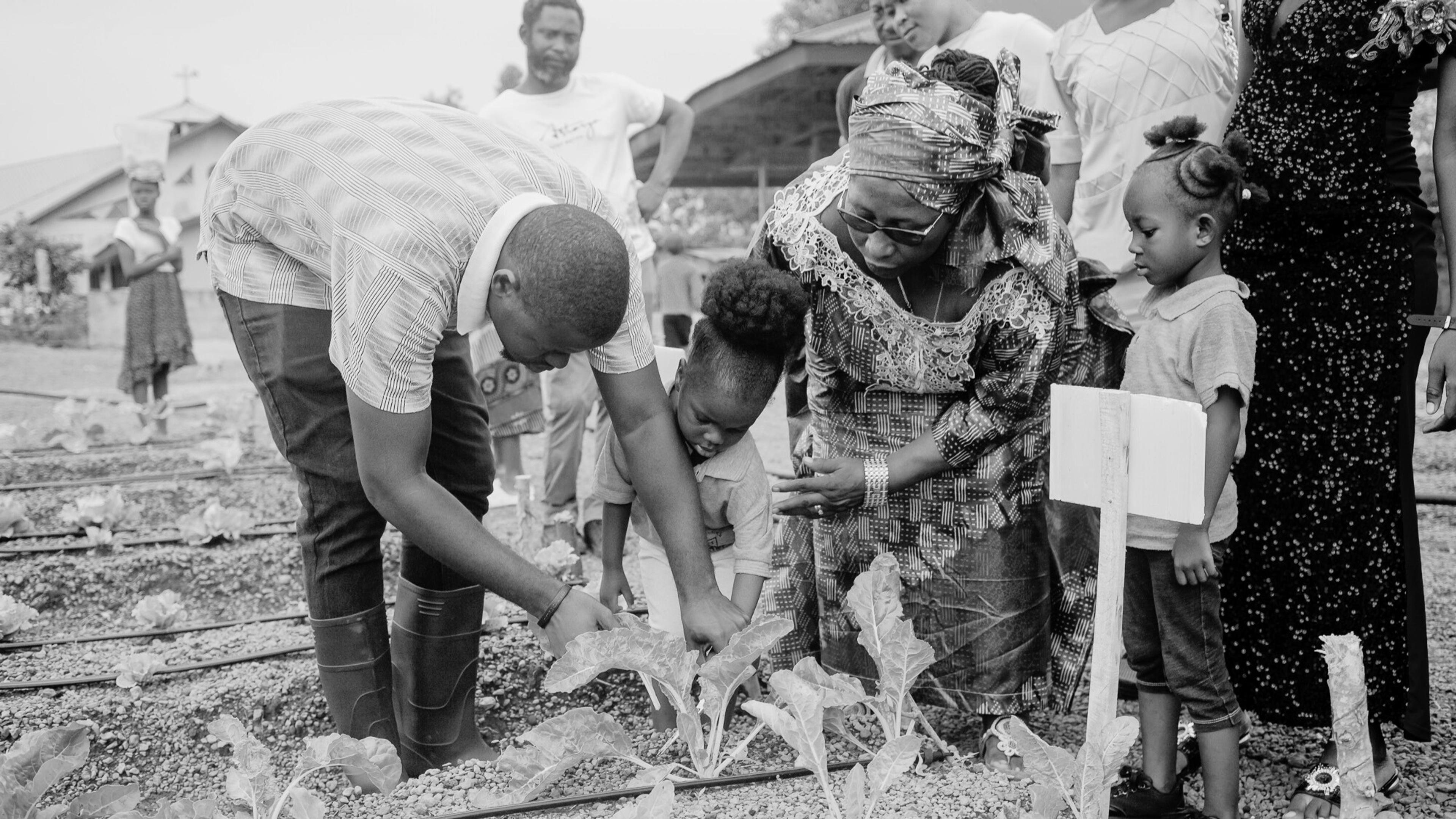 Children and adults planting crops