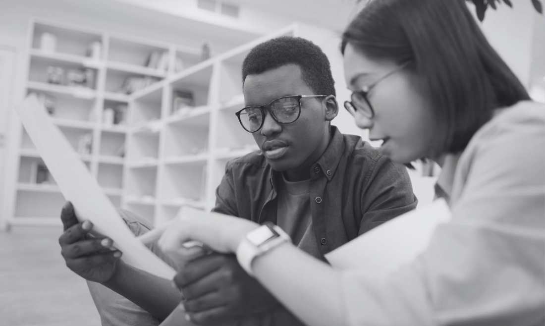 Two college students reading document