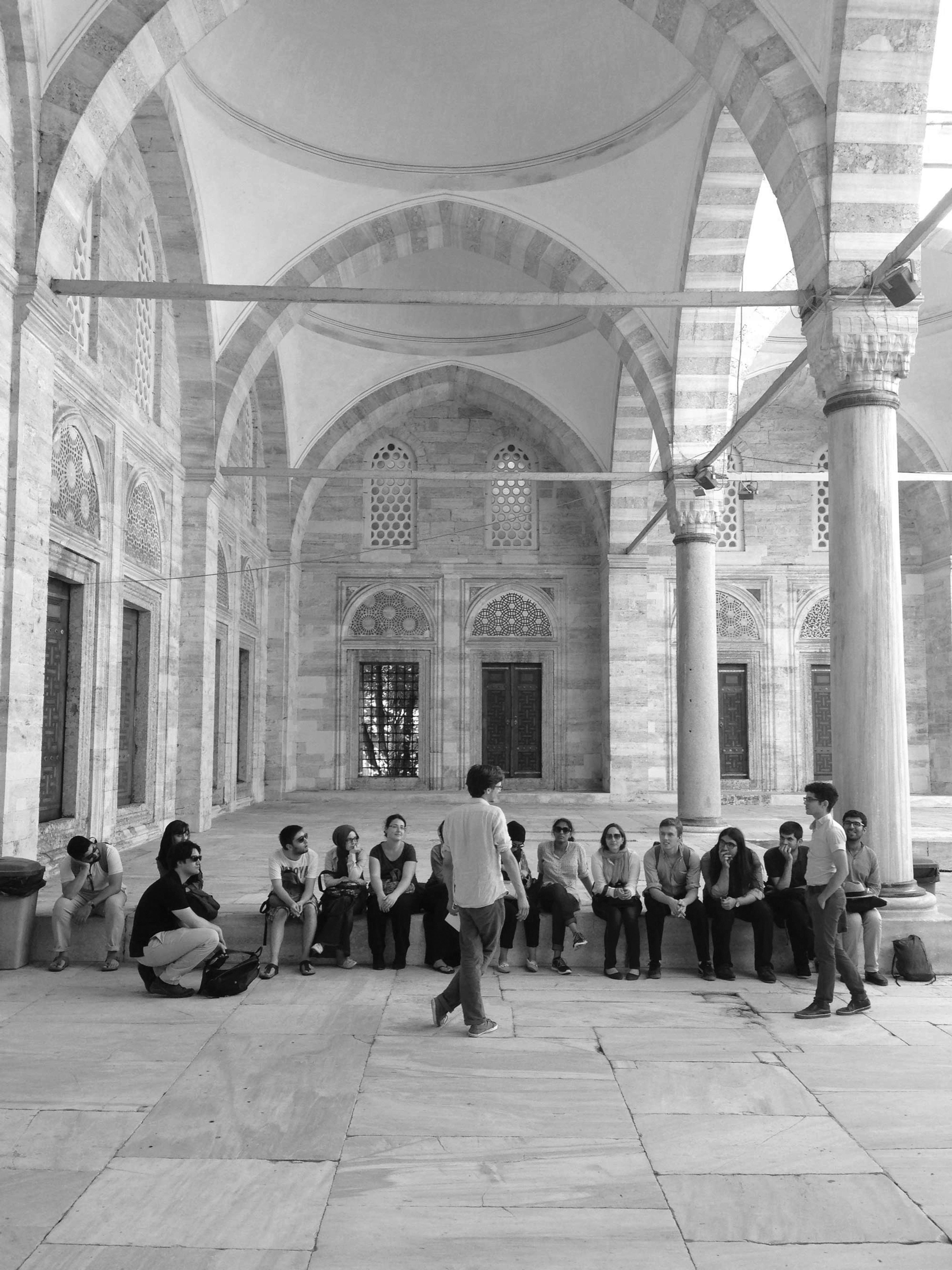 People sitting outside of the Suleymaniye Mosque in Turkey.