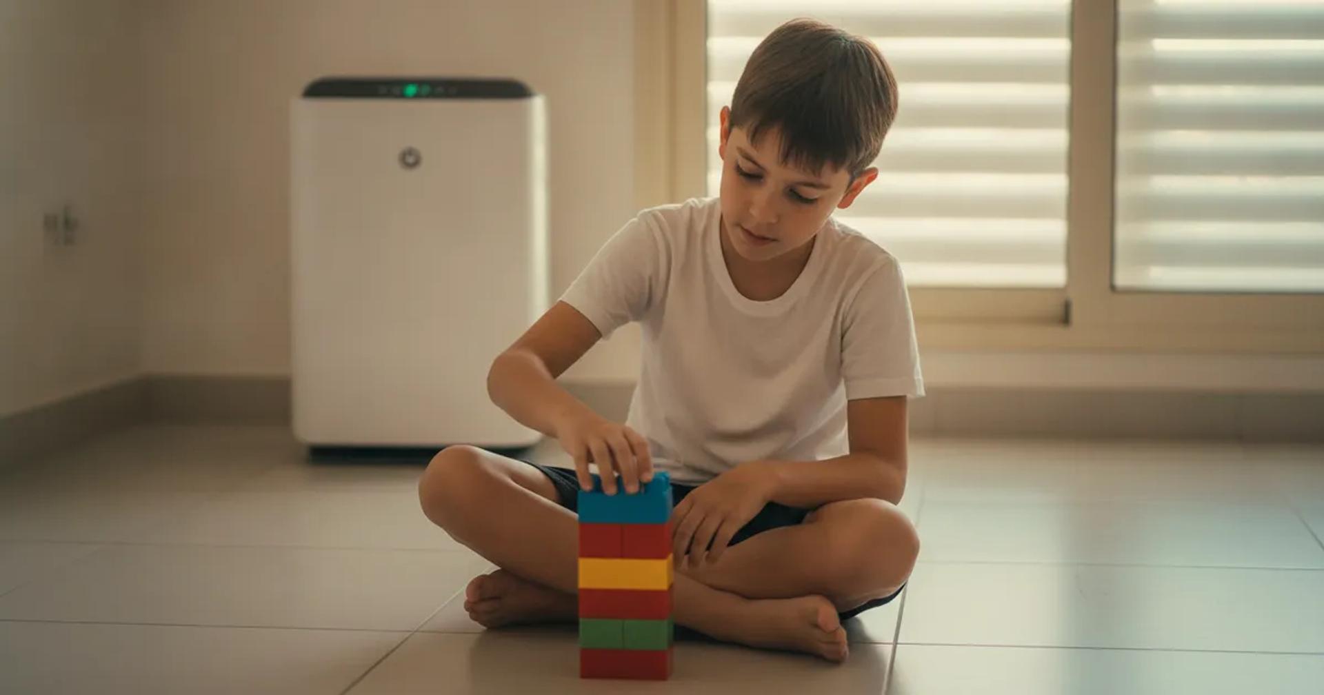 ילד עם אסטמה משחק בסלון ביתי נקי ומאוורר עם מסנן אוויר ברקע