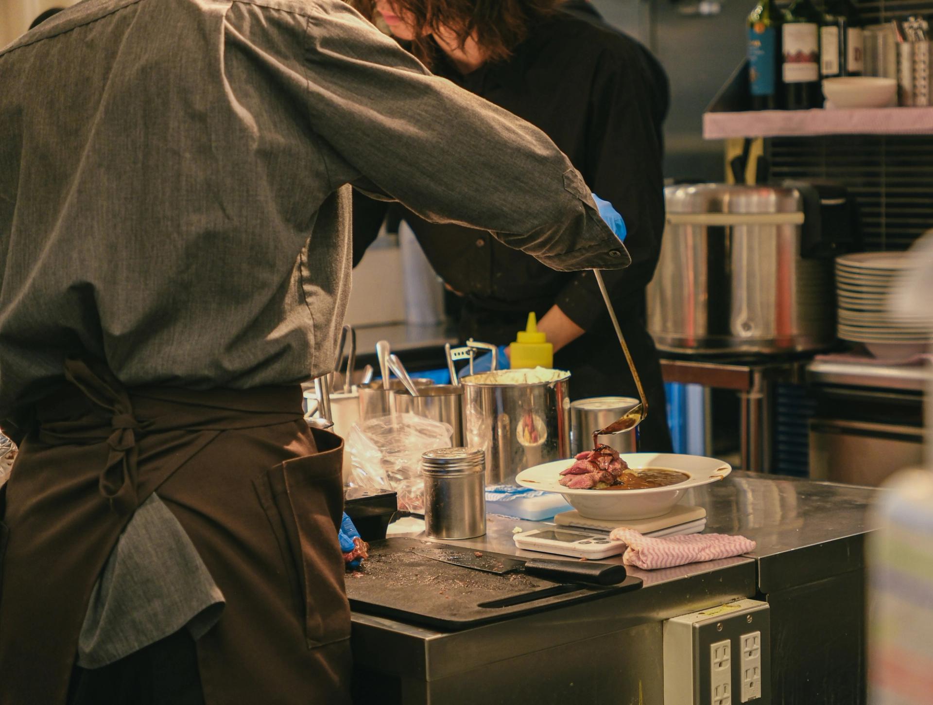 Chef plating un piatto fine dining in cucina