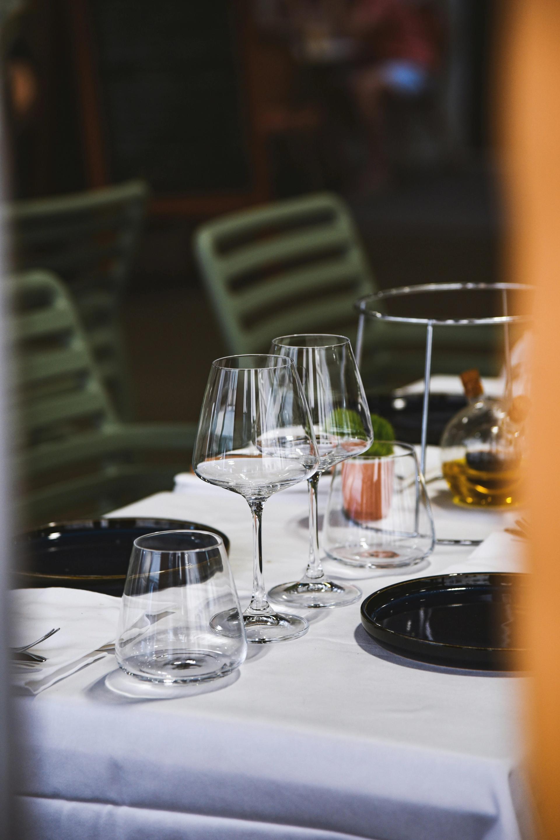 Tavolo elegante con piatti e bicchieri di vino