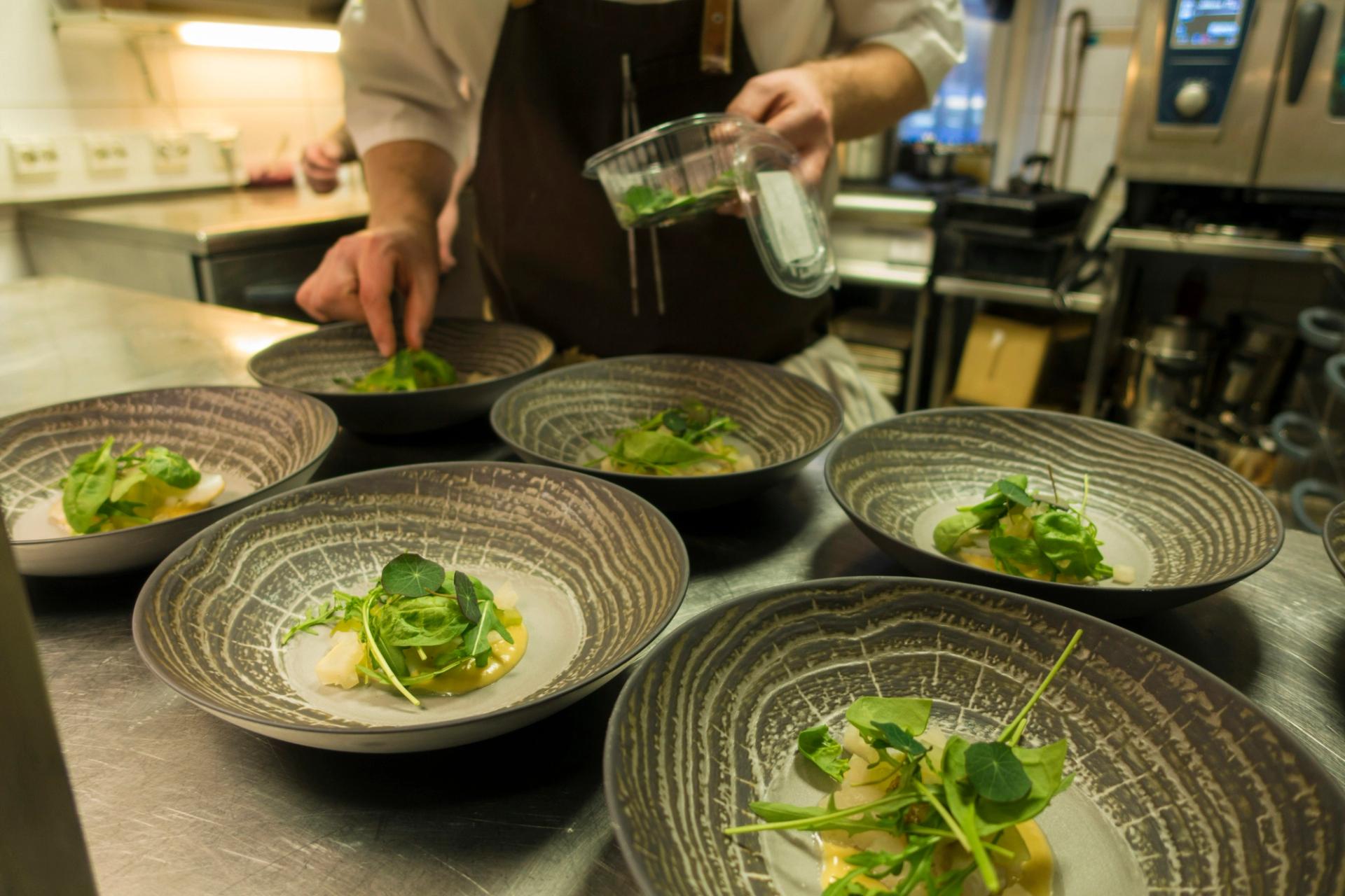 Chef prepara un piatto in cucina fine dining