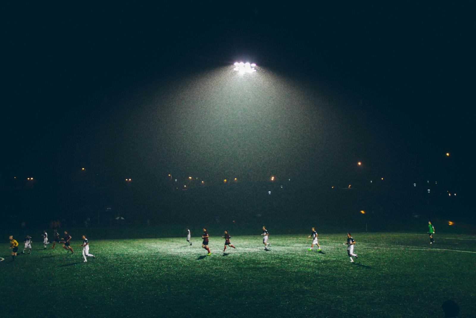 Fußballplatz im Flutlicht bei Nacht