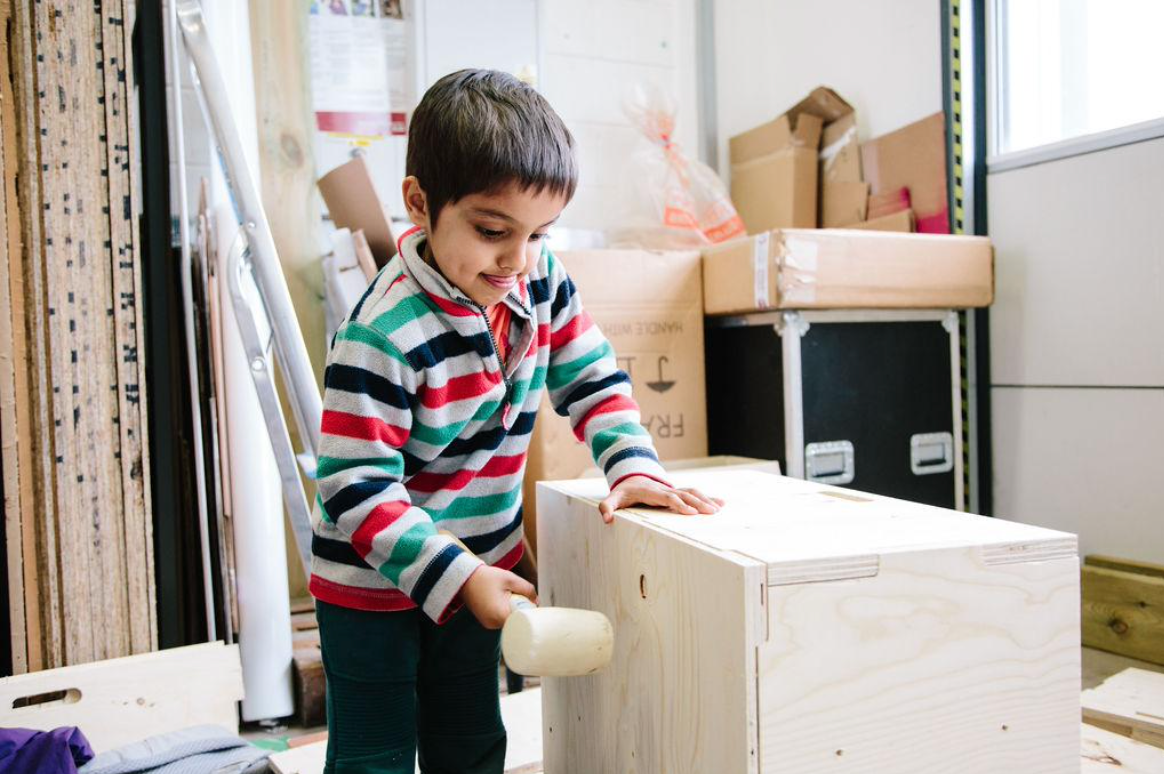 Child learning to build a house
