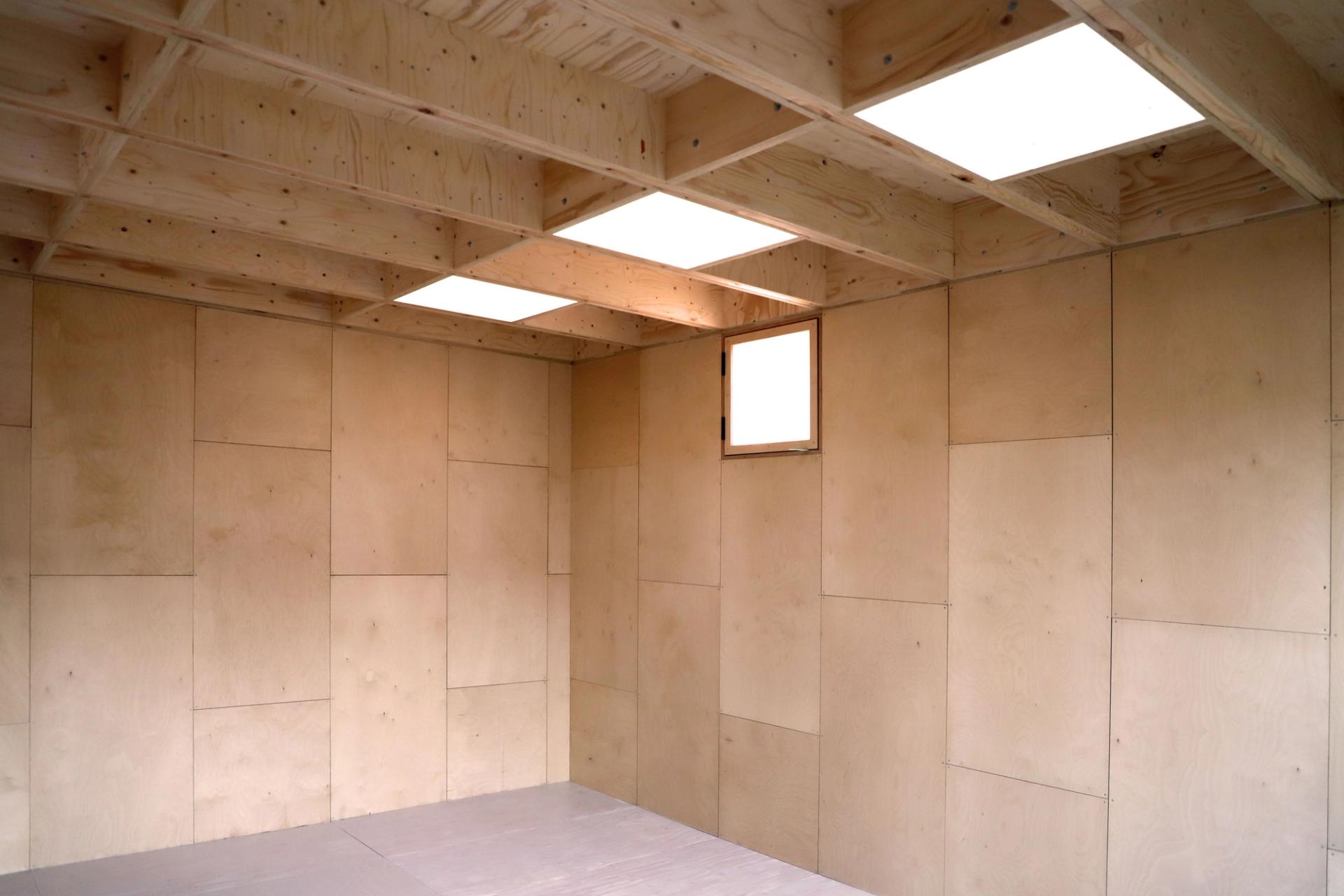 Inside a U-Build garden studio in East London with wooden walls and skylight