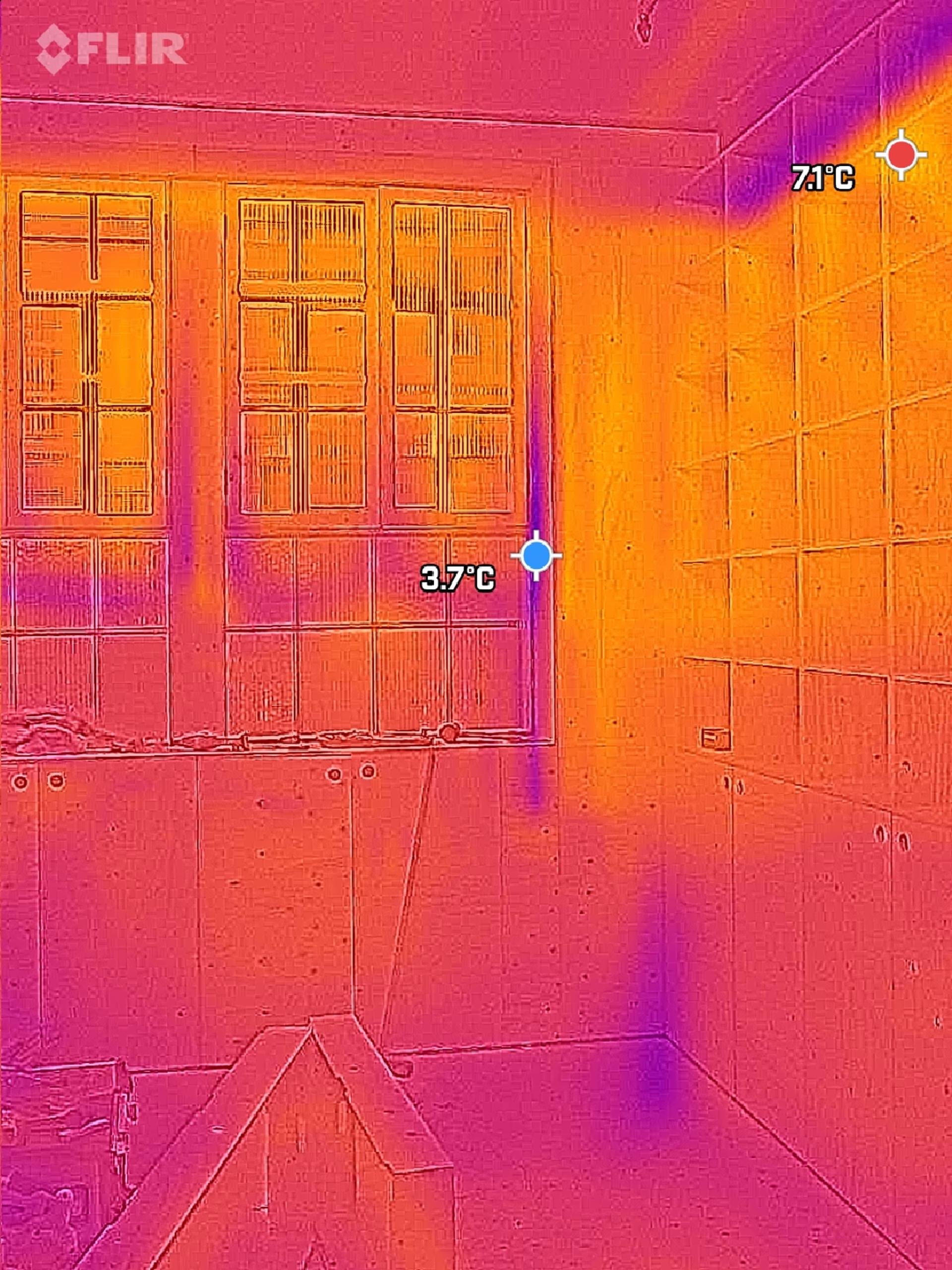 Thermal image of a modular room with windows and shelves. The windows show a cooler temperature (3.7°C), whilst the upper right corner displays a warmer spot (7.1°C). Warm and cool areas are shown in red, yellow, and purple hues.