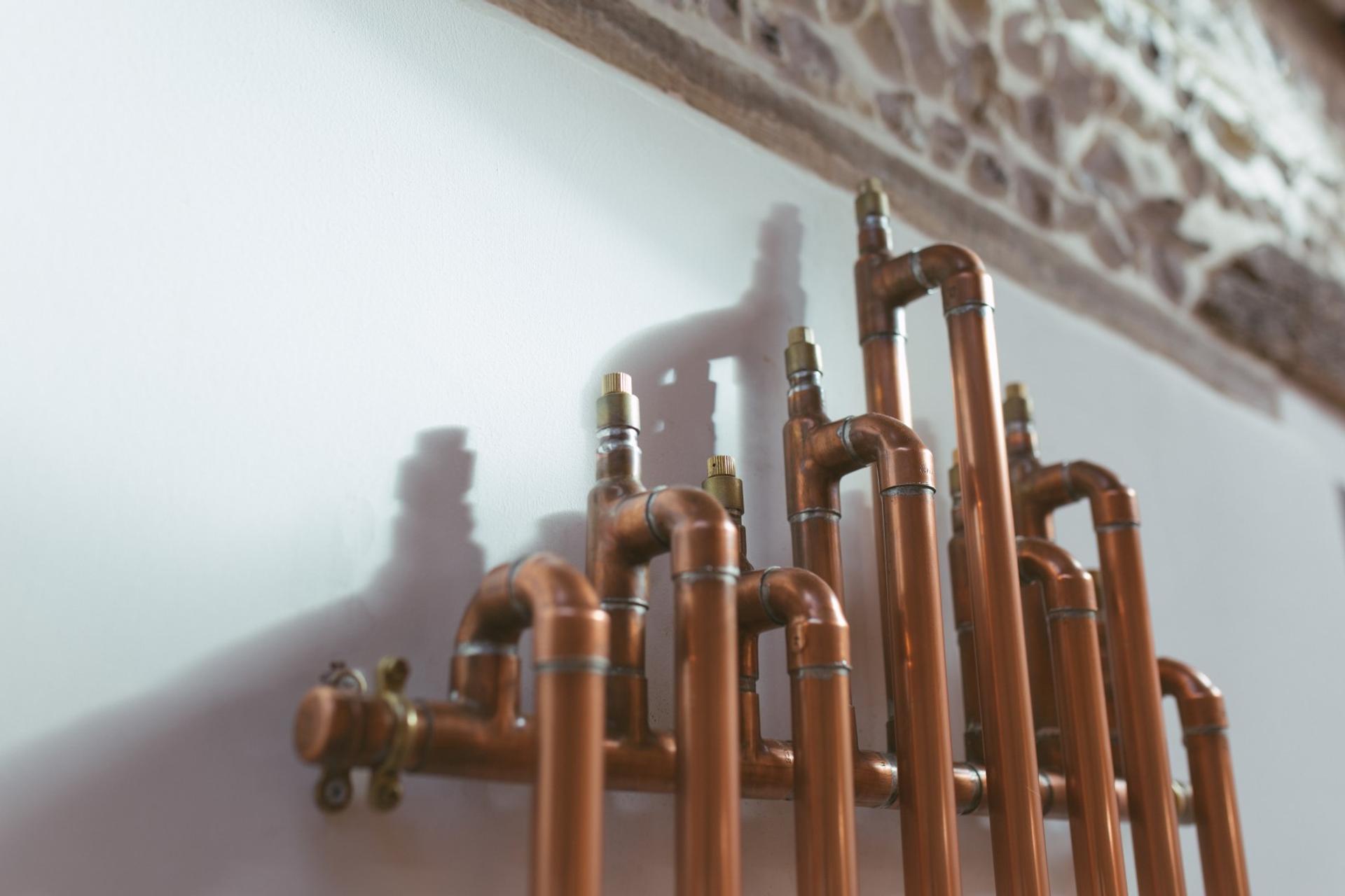 Copper pipes of the bespoke radiator inside a U-Build house