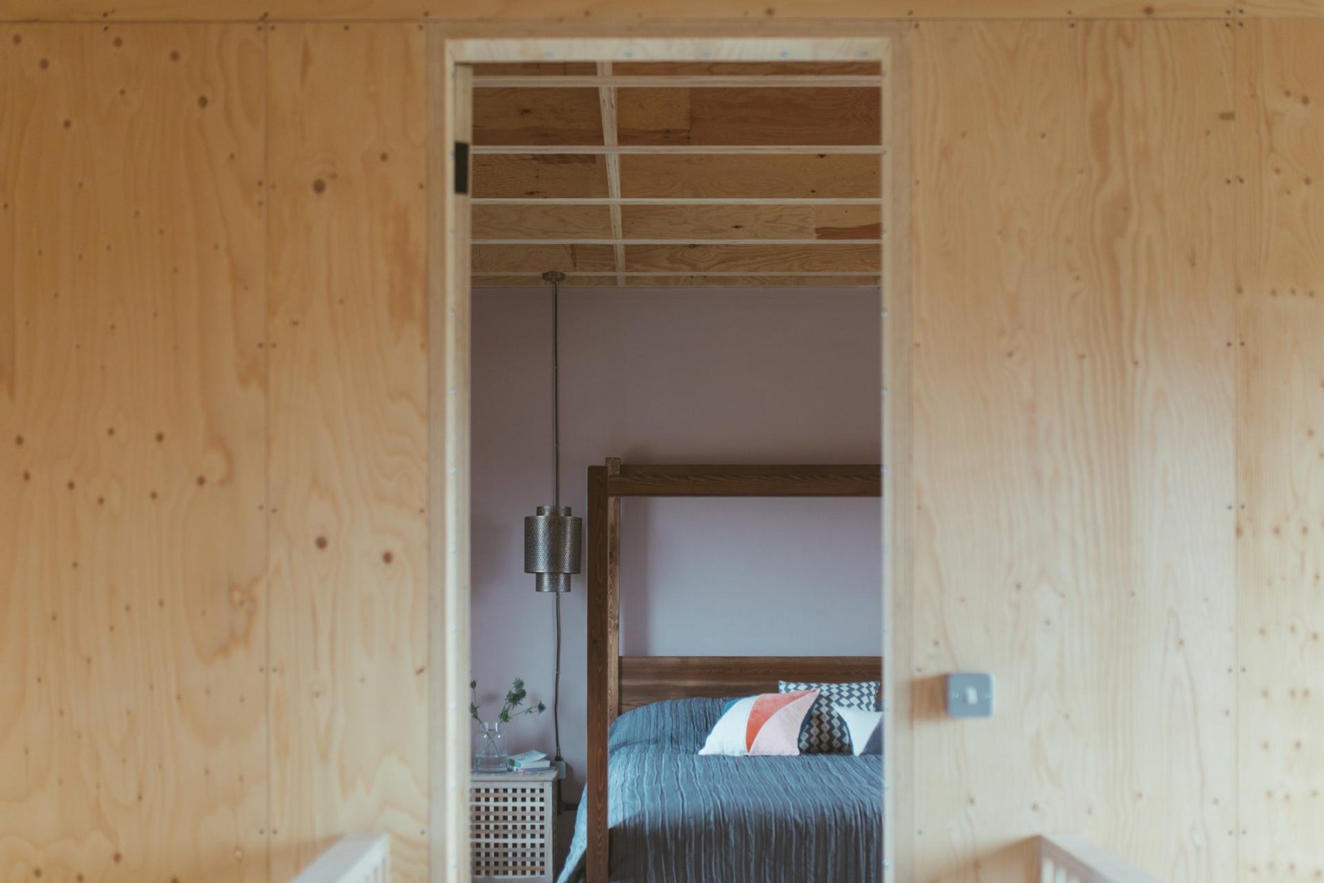 This is an interior bedroom photograph of Box House. It is made of U-Build in collaboration with Studio Bark and has been featured on the Grand Designs TV show.