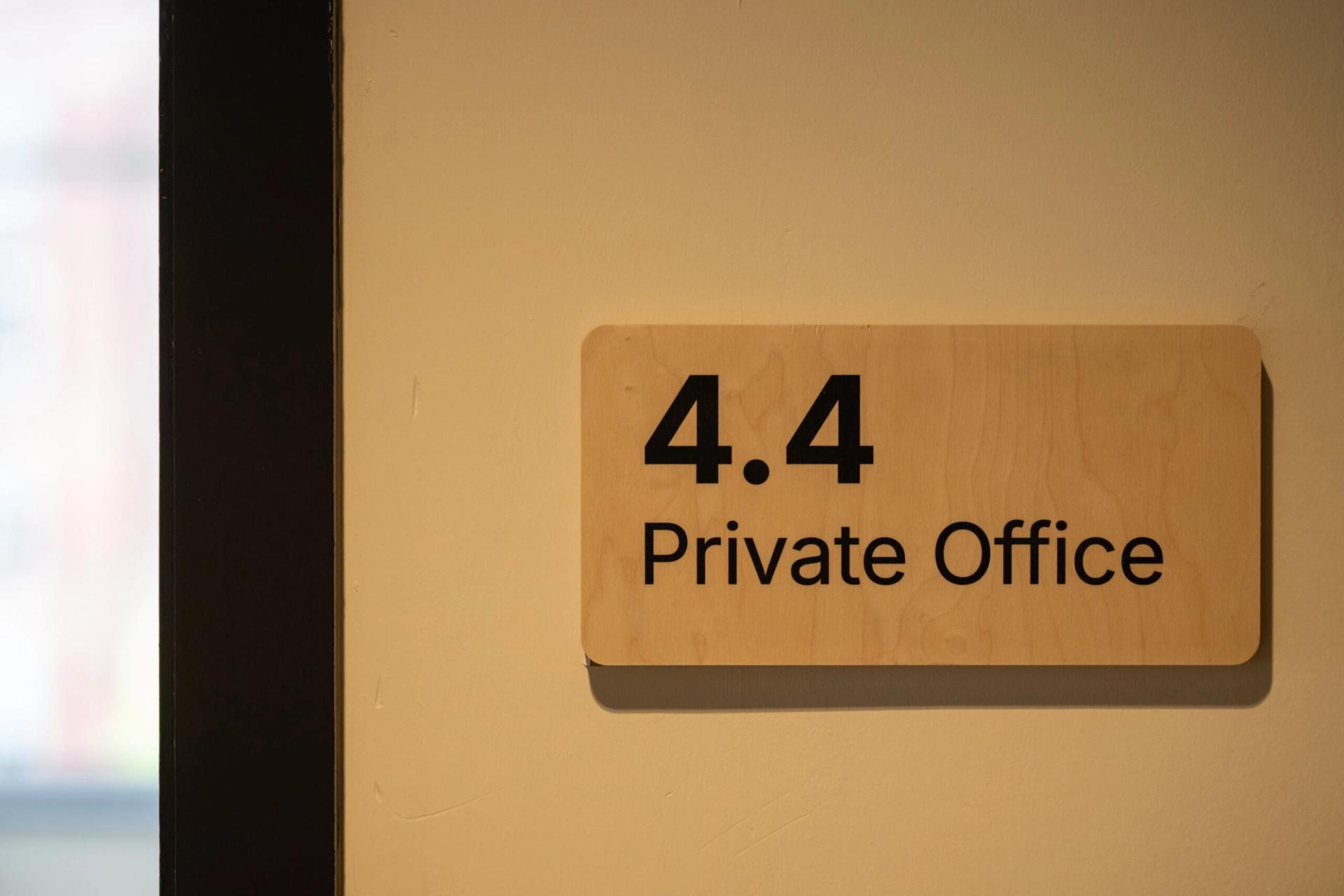 A wooden sign on a beige wall reads 4.4 Private Office, marking the office room number and its designation as a private workspace within Manchester's Sustainable Ventures hub.