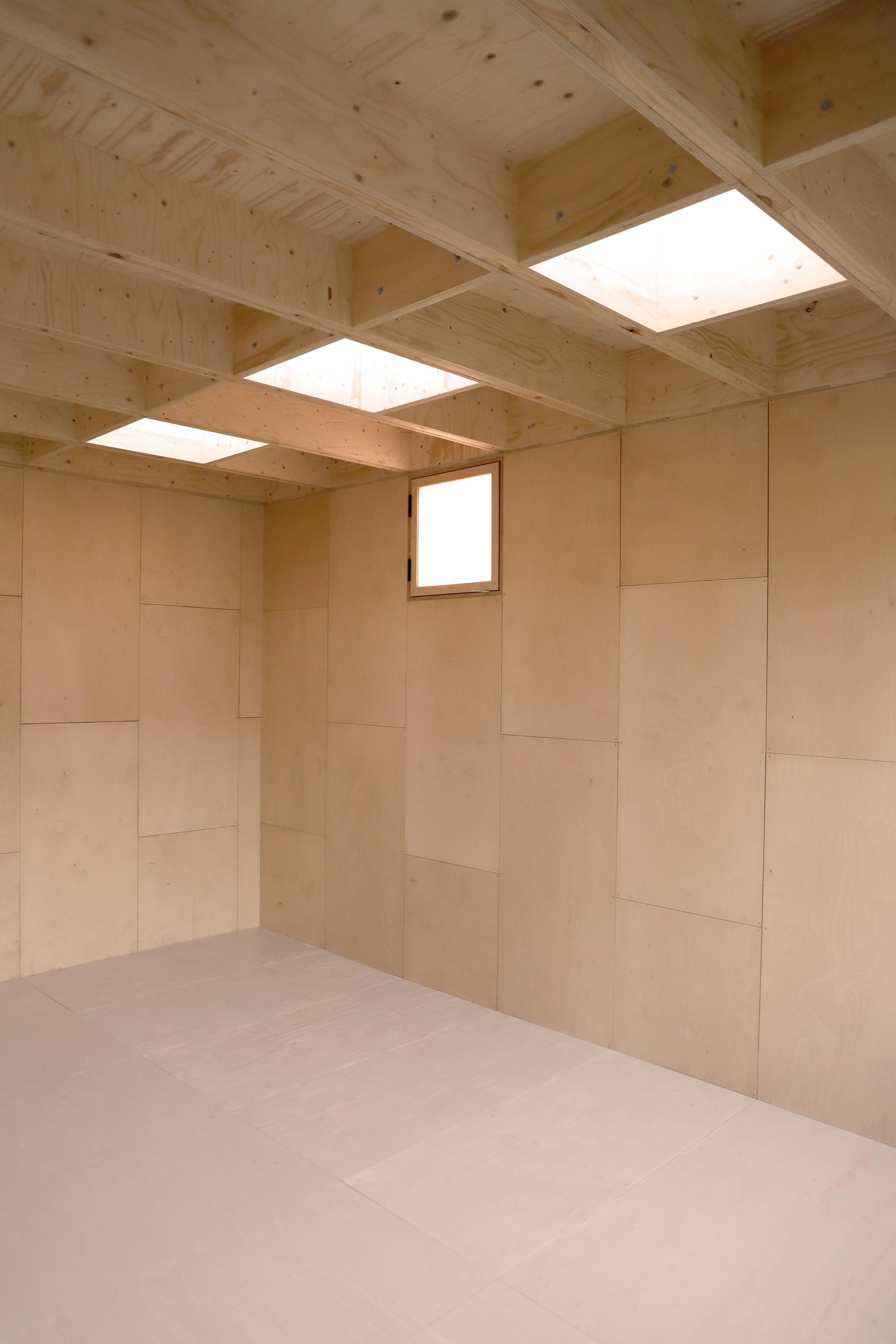 Inside a U-Build garden studio in East London with wooden walls and skylight