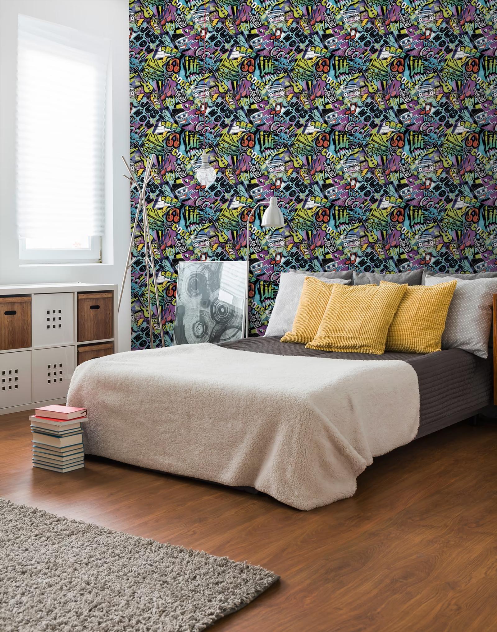 Graffiti wallpaper behind a bed with yellow cushions