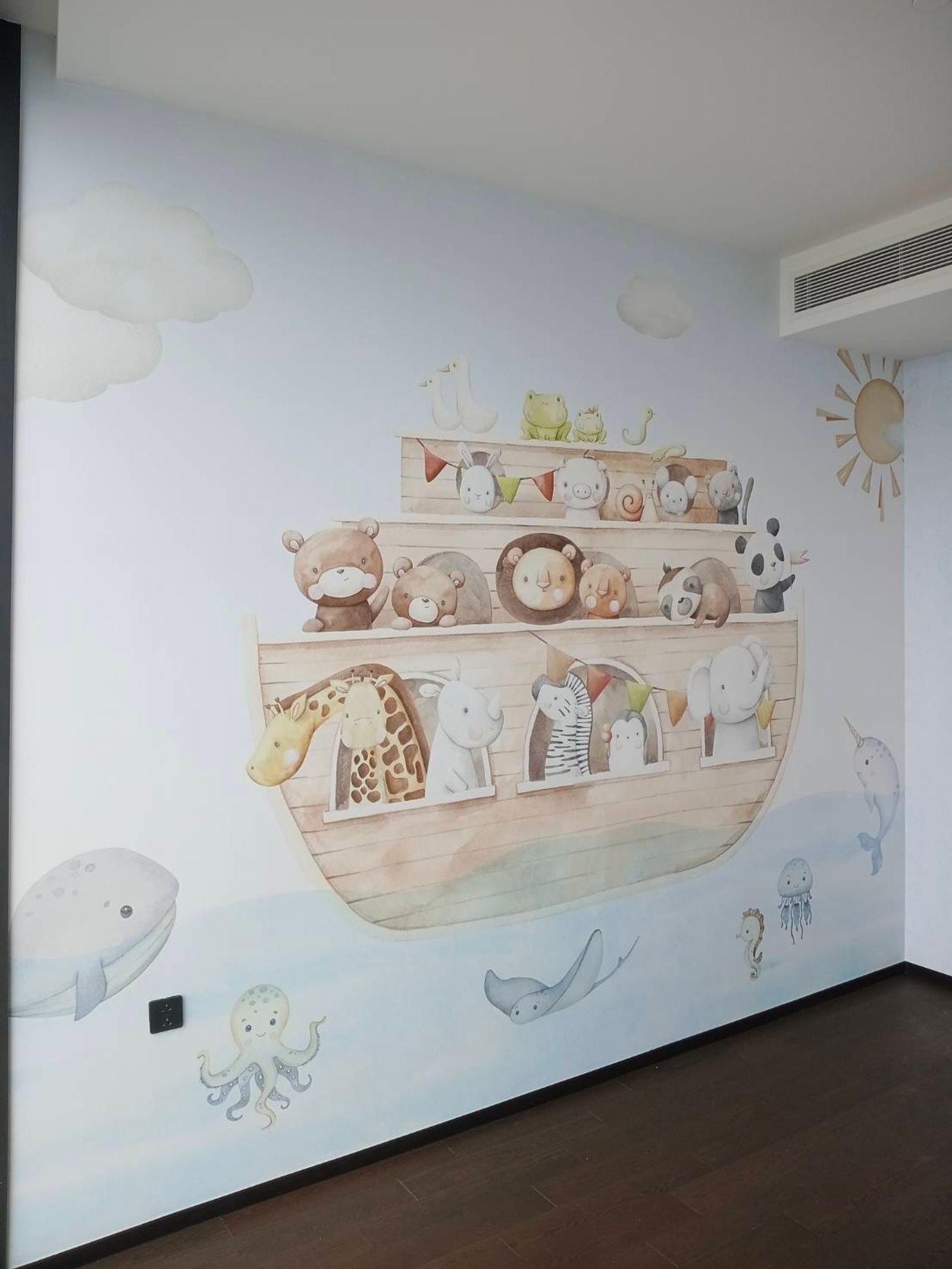 The Noah's Journey wallpaper mural filling a nursery wall in Thonglor — an ark of watercolour animals above a pale blue sea, with a whale, octopus, stingray and jellyfish below