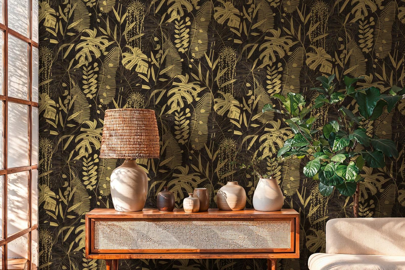 Gold Monstera wallpaper on black behind a rattan console table
