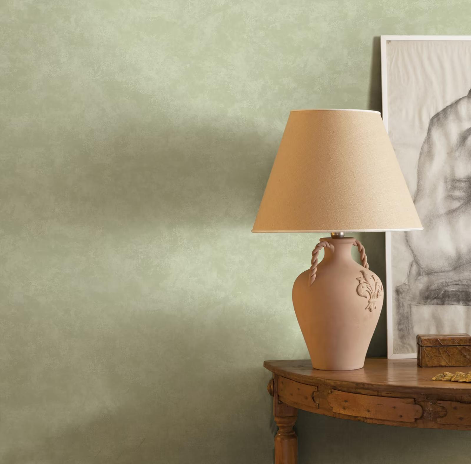 Kanso Sage plaster-effect wallpaper behind a table lamp