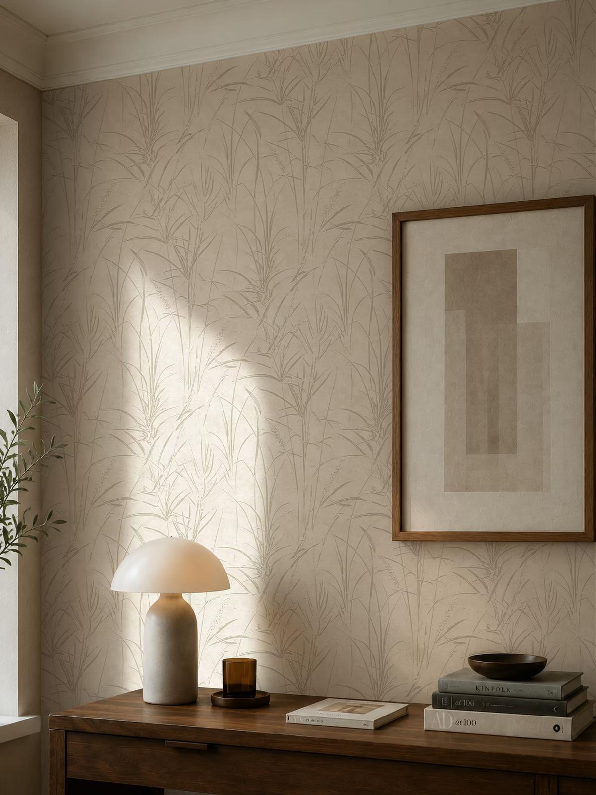 Pale reed-patterned wallpaper in a sunlit corner, above a wooden console with a dome lamp and books