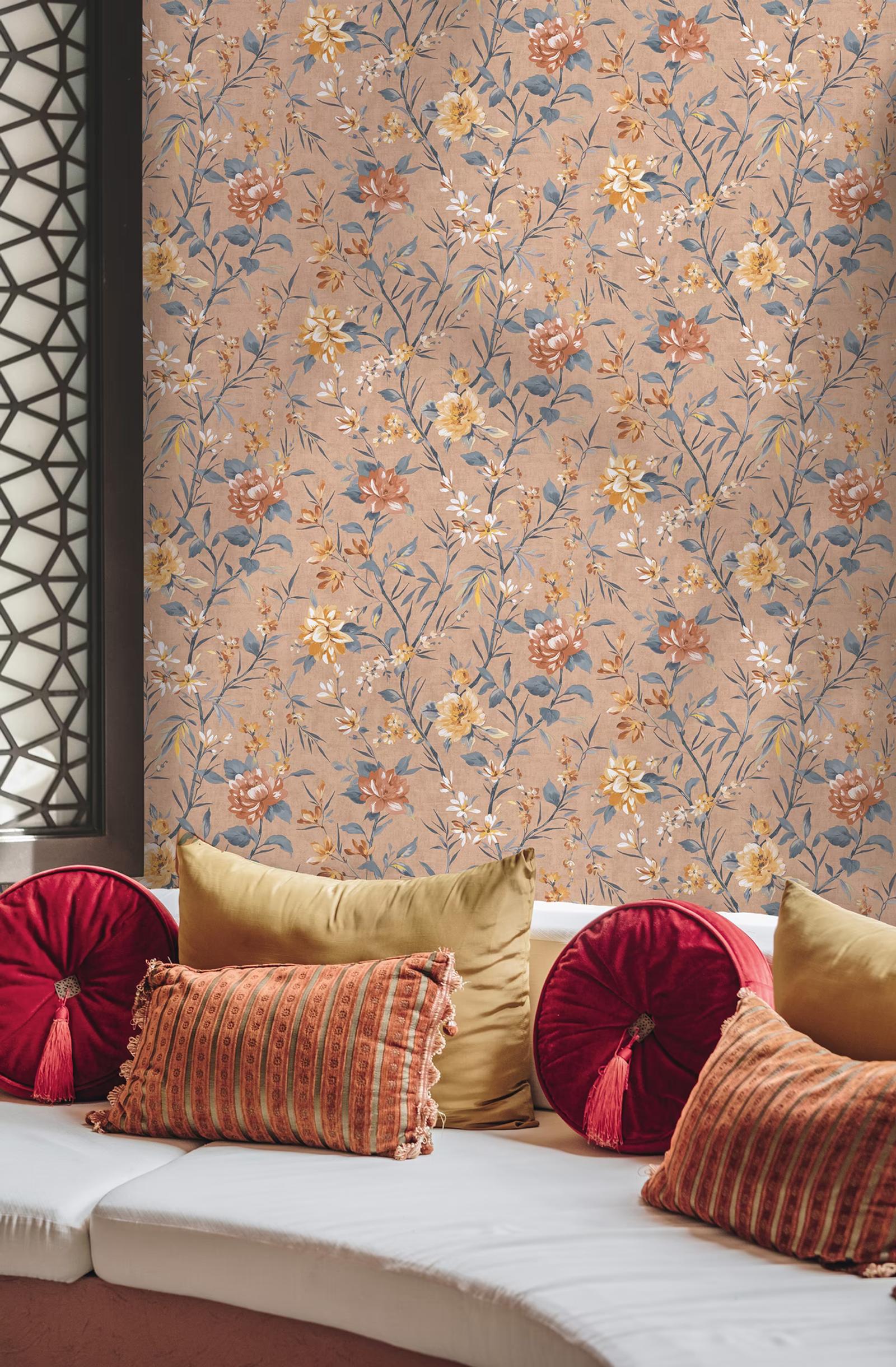 Sazanka Coral floral wallpaper behind velvet cushions