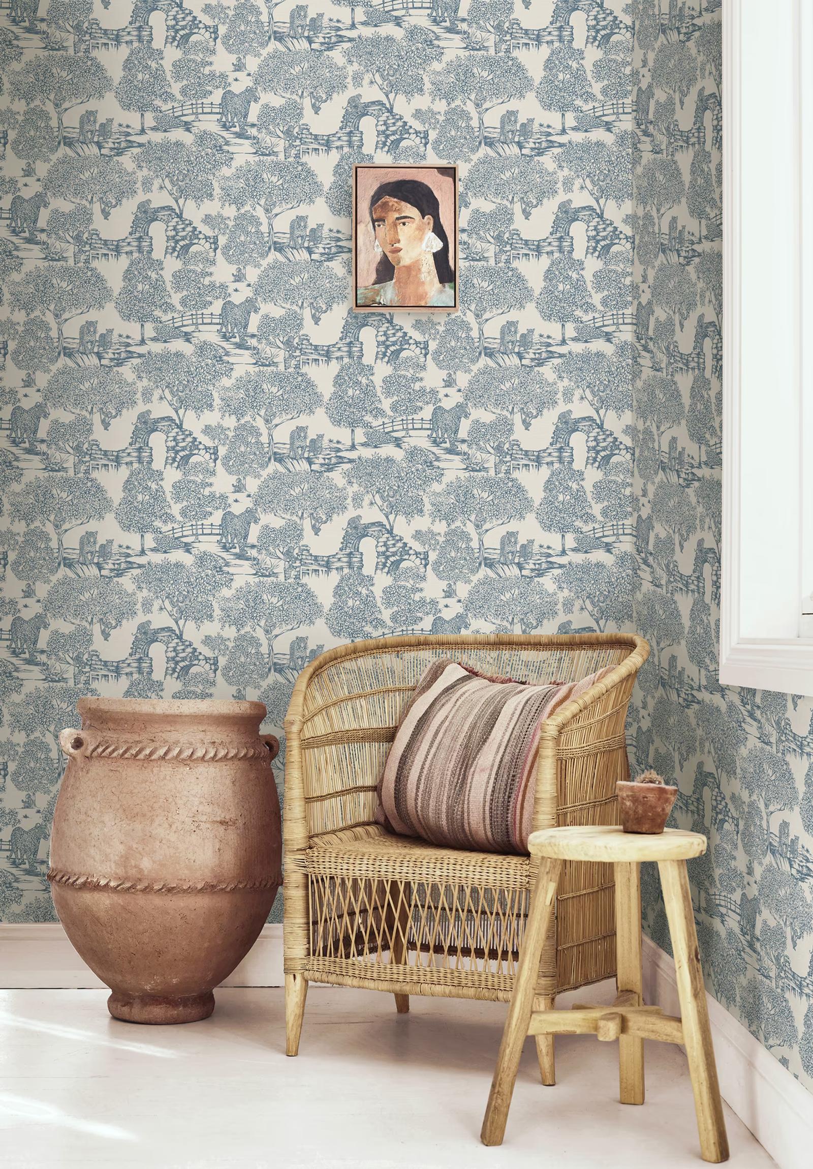 Samar Blue toile wallpaper behind a rattan armchair