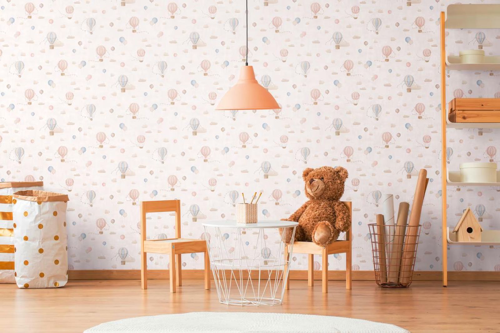 Cream Balloons wallpaper in a child's play corner, with a small wooden table, a teddy bear and a peach pendant light