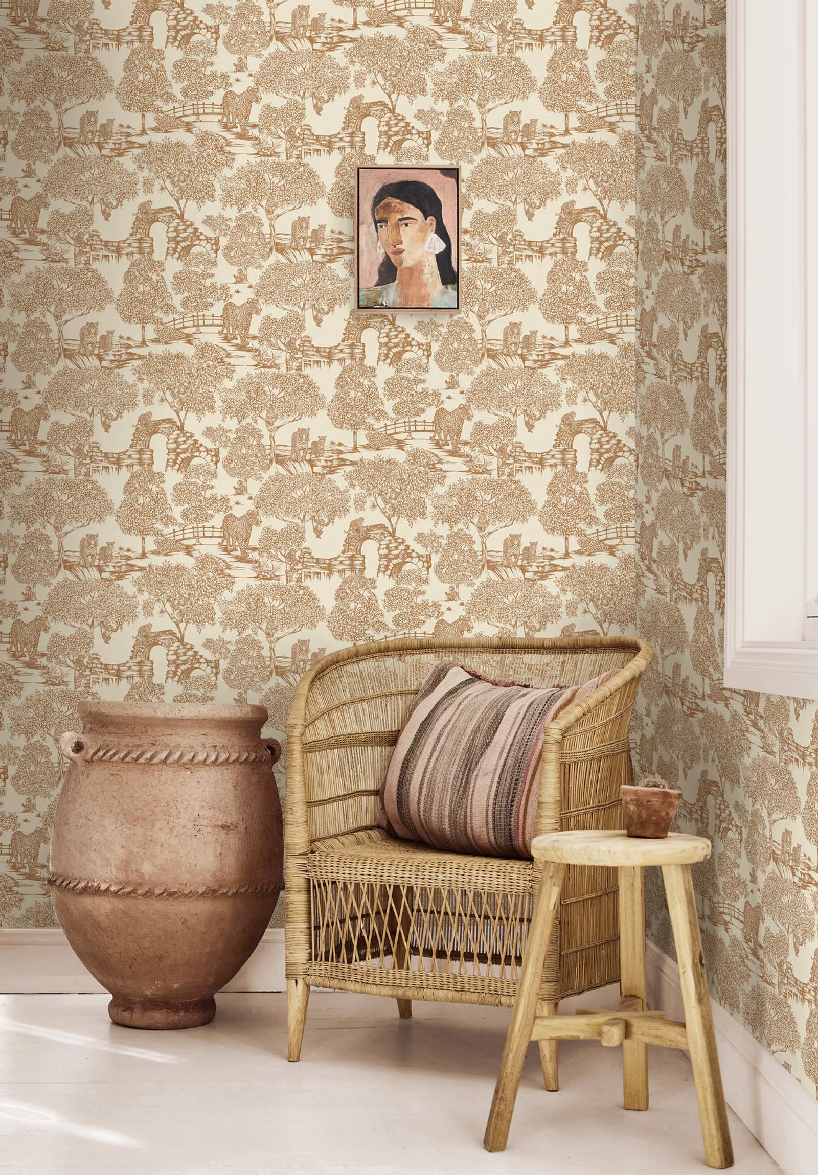 Samar Burnt Orange toile wallpaper behind a rattan armchair