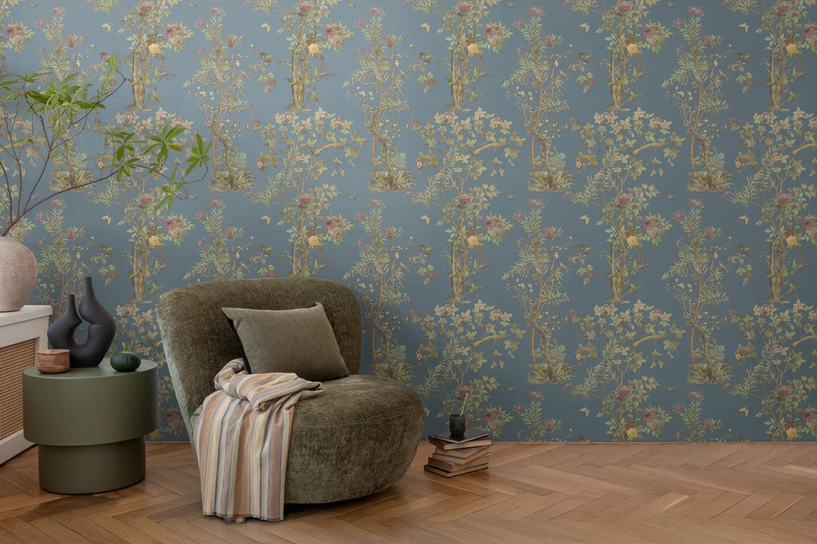 Indigo Chinoiserie wallpaper behind an olive bouclé chair on herringbone floor