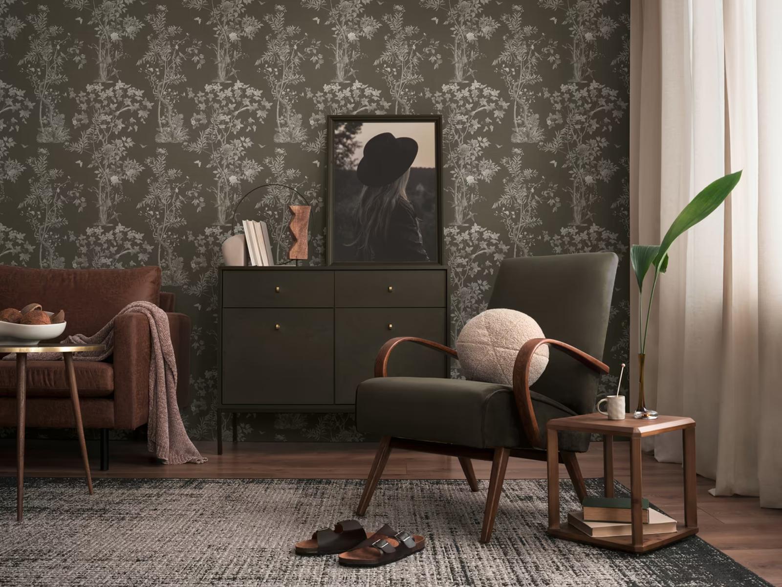 Ebony Chinoiserie wallpaper in a dark living room with a black leather chair