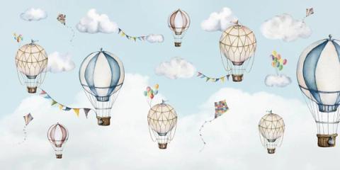 Hot air balloons, kites and paper bunting drifting through a pale blue sky.