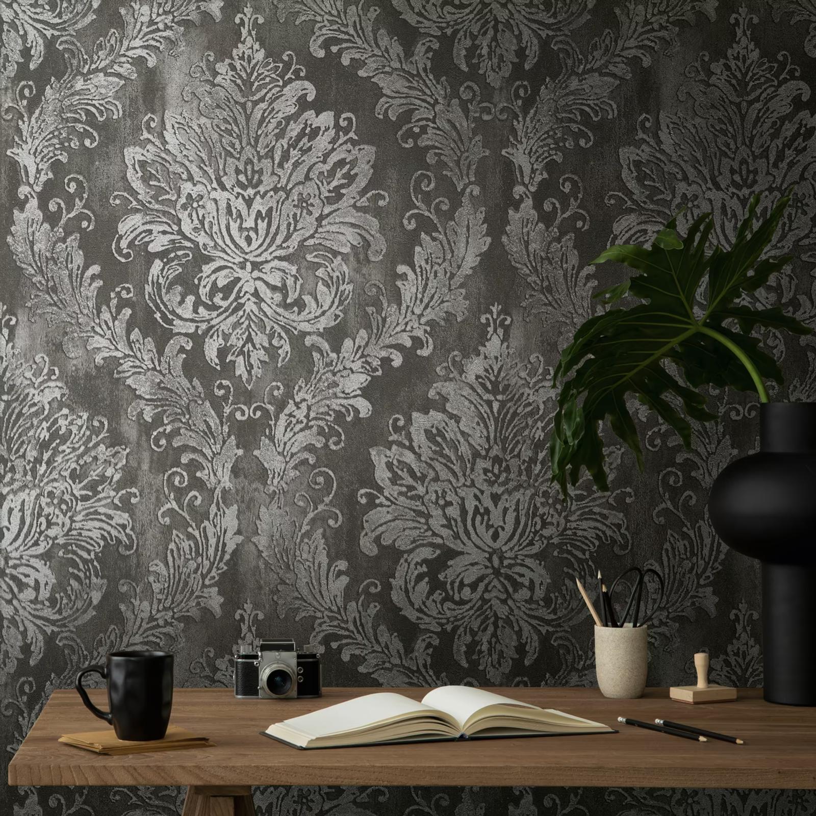Ebony Damask wallpaper above a desk with an open book and camera