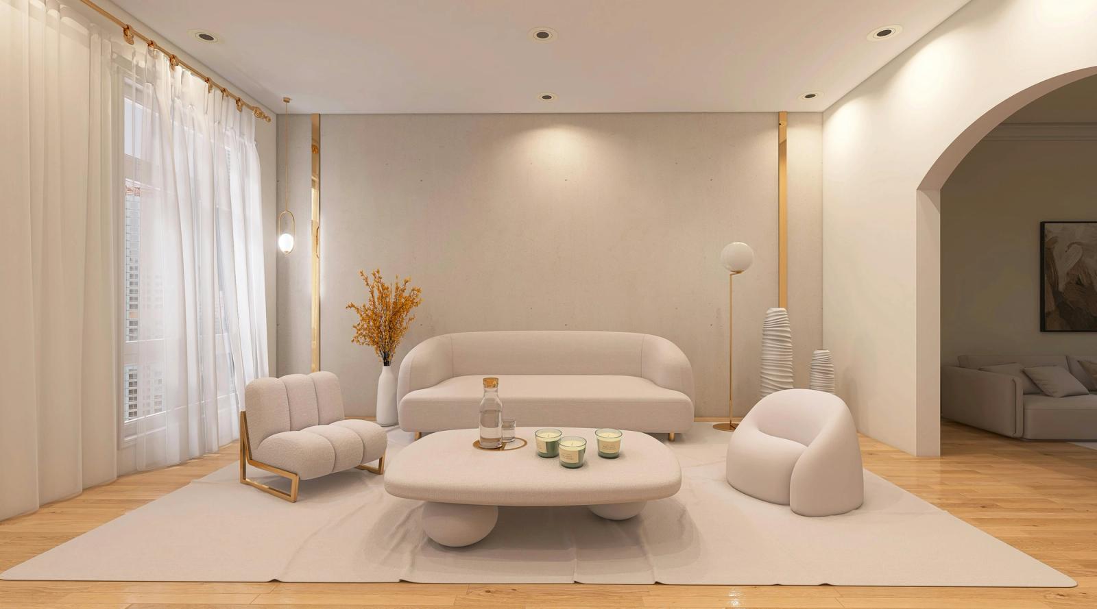 A minimal cream living room with curved sofas, a low round table and a plain textured wall in warm off-white
