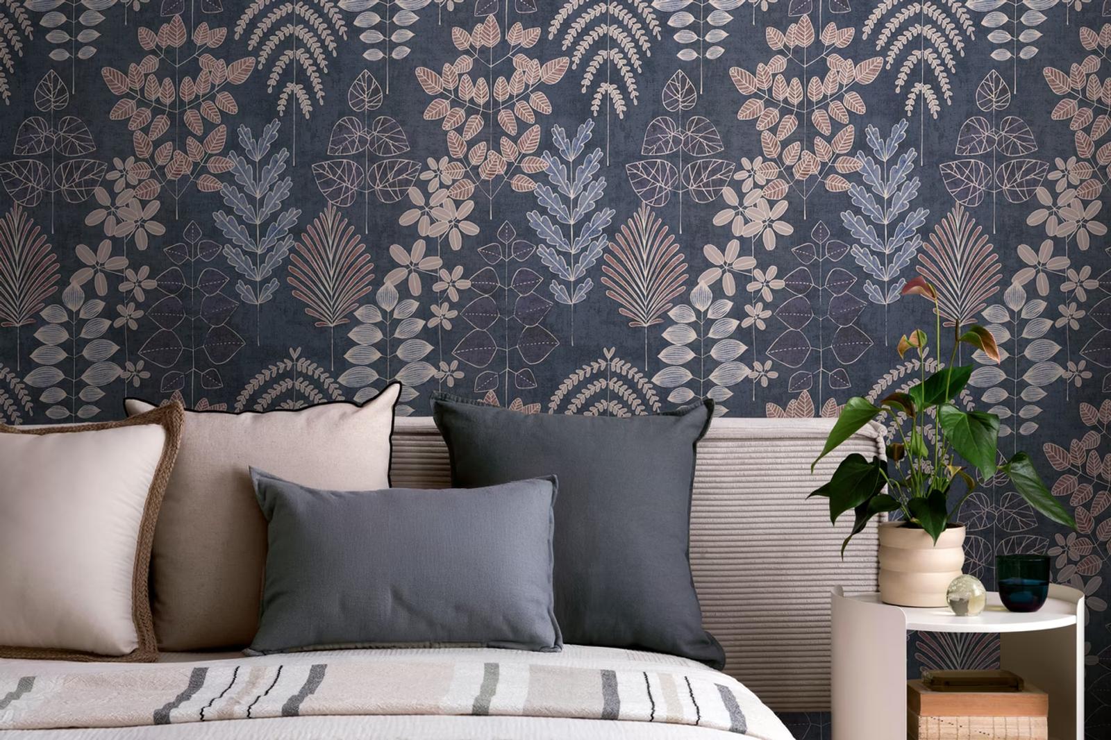 Midnight Herbarium wallpaper on navy behind a bed with grey cushions