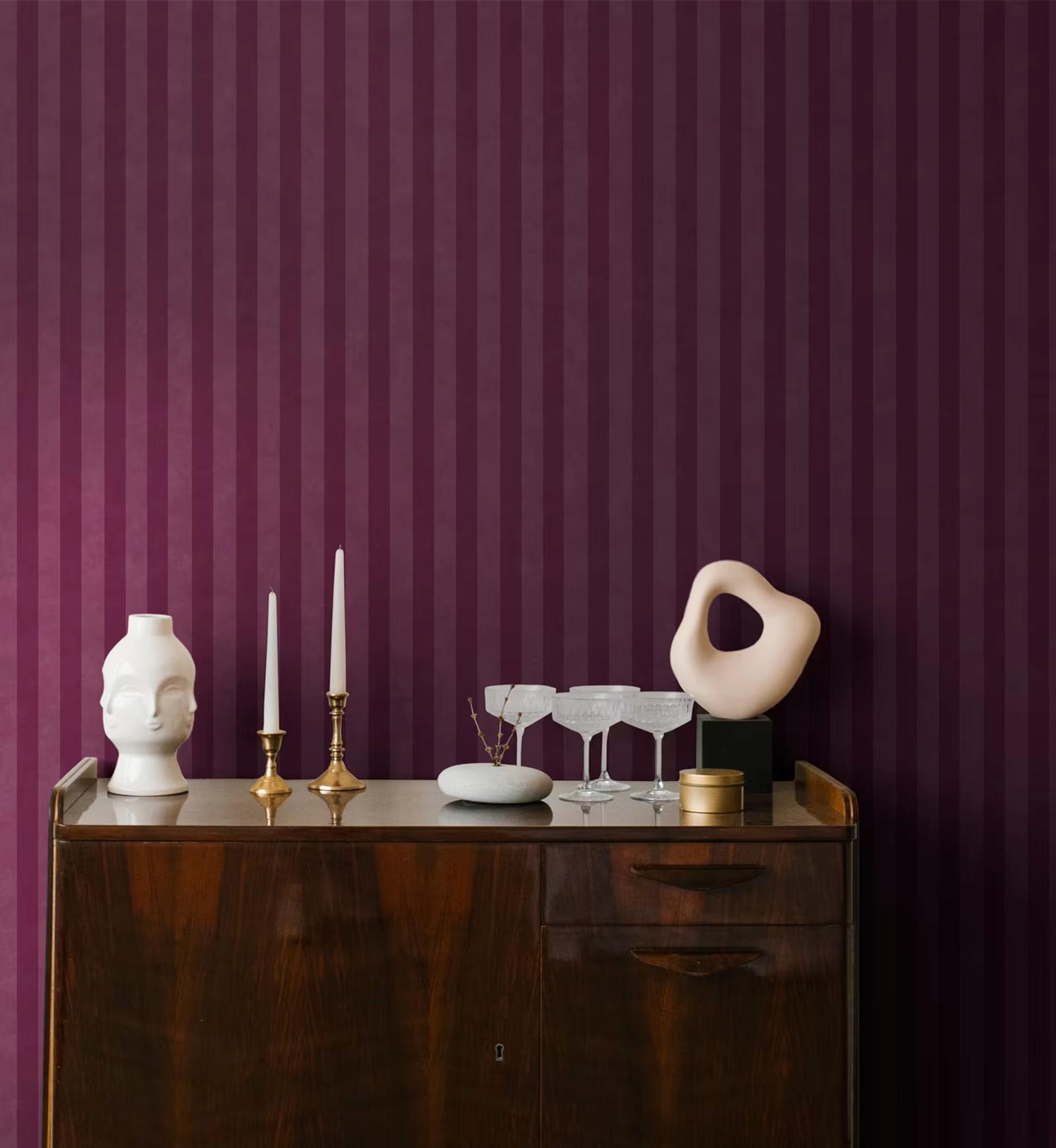 Aquila Berry stripe wallpaper behind a walnut sideboard